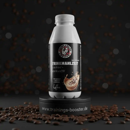Weiße Trinkmahlzeit-Flasche mit Kaffeegeschmack auf einem Podest umgeben von Kaffeebohnen.