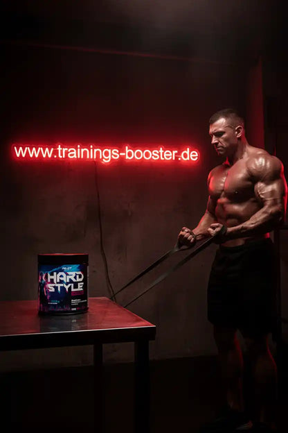 Muskulöser Mann trainiert mit Widerstandsbändern neben Hard Style Booster-Dose