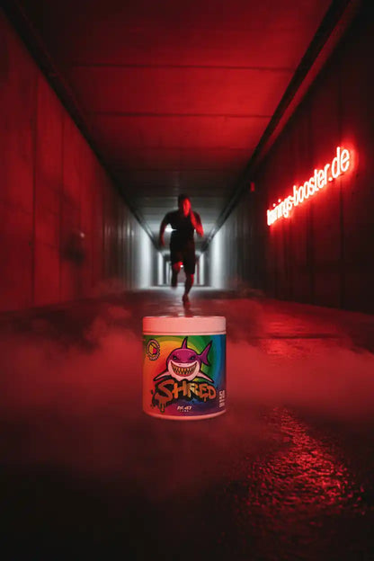 SHRED Fatburner Dose mit Hai-Design im roten Tunnel mit Laufender Person