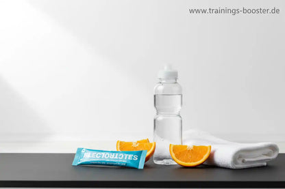 Elektrolyt-Booster mit Orange und Wasserflasche für Sport und Fitness