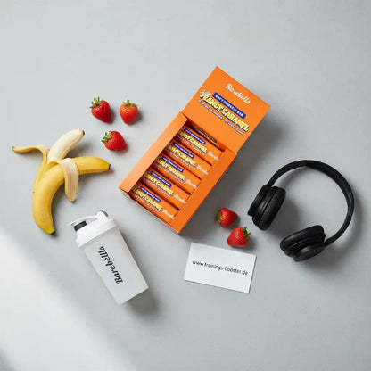 Barebells Peanut Caramel Proteinriegel mit Banane, Erdbeeren, Shaker und Kopfhörern – ideal für Sport und Training