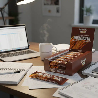Vegan Protein Bar Orange Chocolate von Barebells auf Schreibtisch mit Laptop und Kaffee