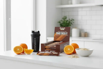 Vegan Protein Bar Orange Chocolate mit Shaker, Orangen und Haferflocken in moderner Küche