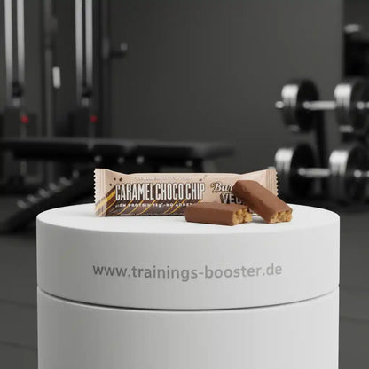 Caramel Choco Chip Proteinriegel mit 15g Eiweiß, ideal für Sport und Fitness, präsentiert auf weißem Podest im Studio