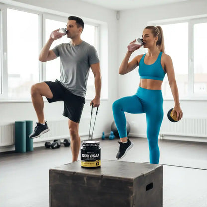 Mann und Frau trinken BCAA-Booster während des Trainings im Fitnessstudio