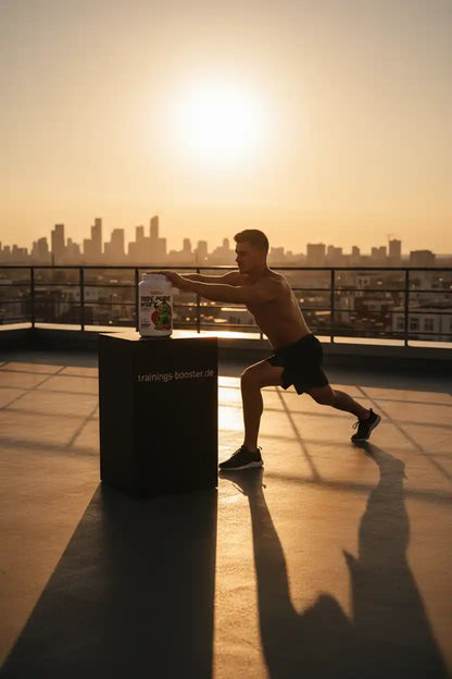 Muskulöser Mann trainiert auf Dach mit Whey-Protein-Booster bei Sonnenuntergang
