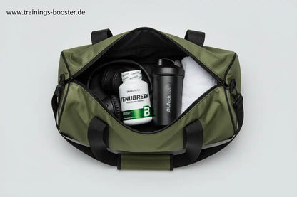 Grüne Sporttasche mit Fenugreek-Booster, Shaker und Kopfhörern für Training und Fitness