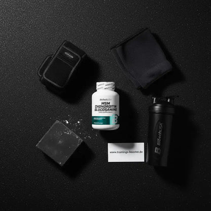 MSM Chondroitin Glucosamin Sportnahrung mit Shaker und Trainingszubehör auf schwarzem Hintergrund