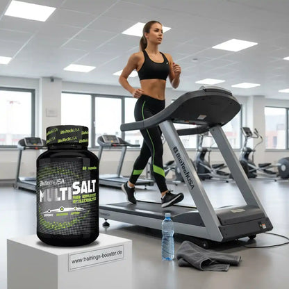 BioTechUSA Multisalt Elektrolyt-Kapseln im Fitnessstudio neben Laufband und Wasserflasche