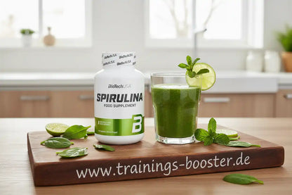 Spirulina Nahrungsergänzungsmittel von BioTechUSA mit grünem Smoothie, Limette und Minze auf Holzbrett
