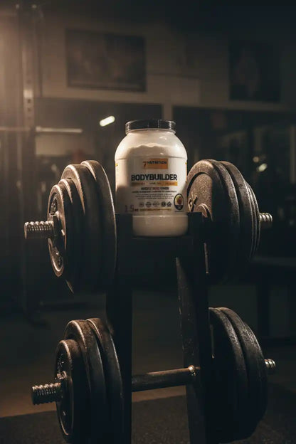 Bodybuilder Protein Powder mit Hanteln im Fitnessstudio