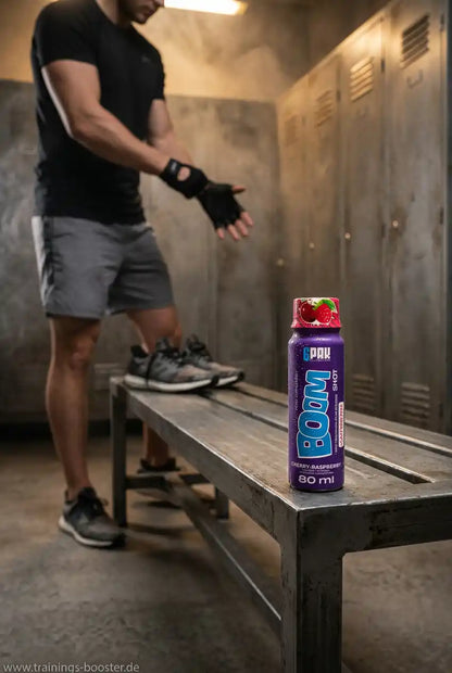 TREC NUTRITION BOOM Pre Workout Shot Kirsche-Himbeere auf einer Bank im Fitnessstudio