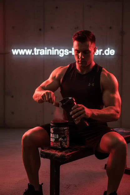 Muskulöser Mann bereitet Sportnahrung mit Booster vor, ideal für Training und Fitness