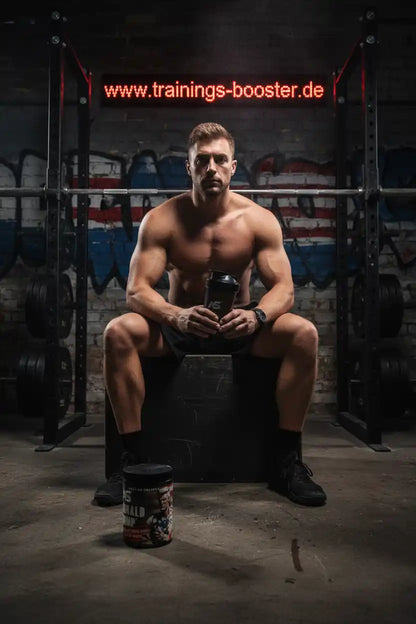 Muskulöser Mann mit Proteinshake im Fitnessstudio, ideal für Booster und Fatburner
