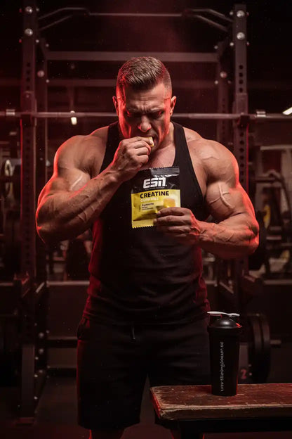 Muskulöser Mann isst Creatine Gummies im Fitnessstudio – ideal für Training & Muskelaufbau
