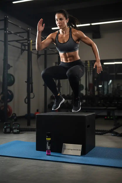 Frau beim Boxspring-Training mit Sportnahrung und Booster im Fitnessstudio