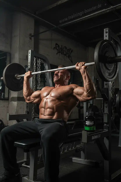 Muskulöser Mann beim Gewichtheben mit Tribulus Maximus Booster im Fitnessstudio